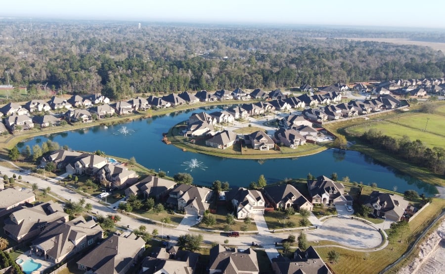 Houses nestled beside a tranquil, small lake in Houston, Texas