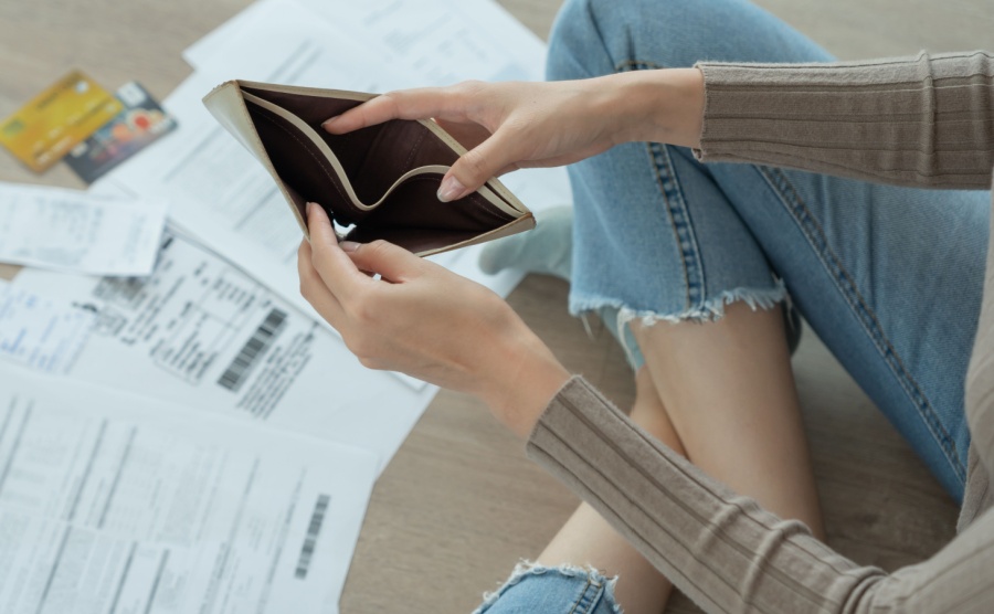 Woman looks into an empty wallet