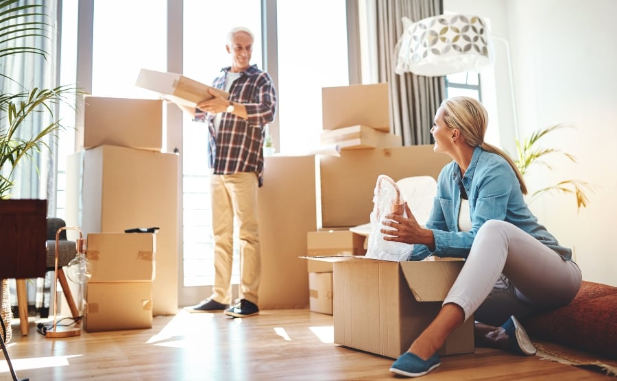 Senior couple unpacking boxes in new home