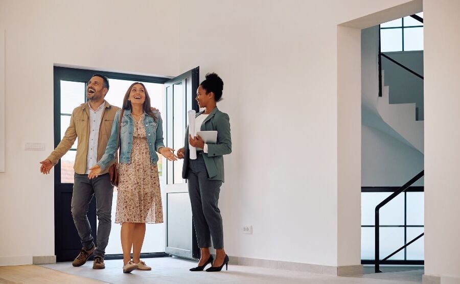 Estate agent showing a couple the inside of a property