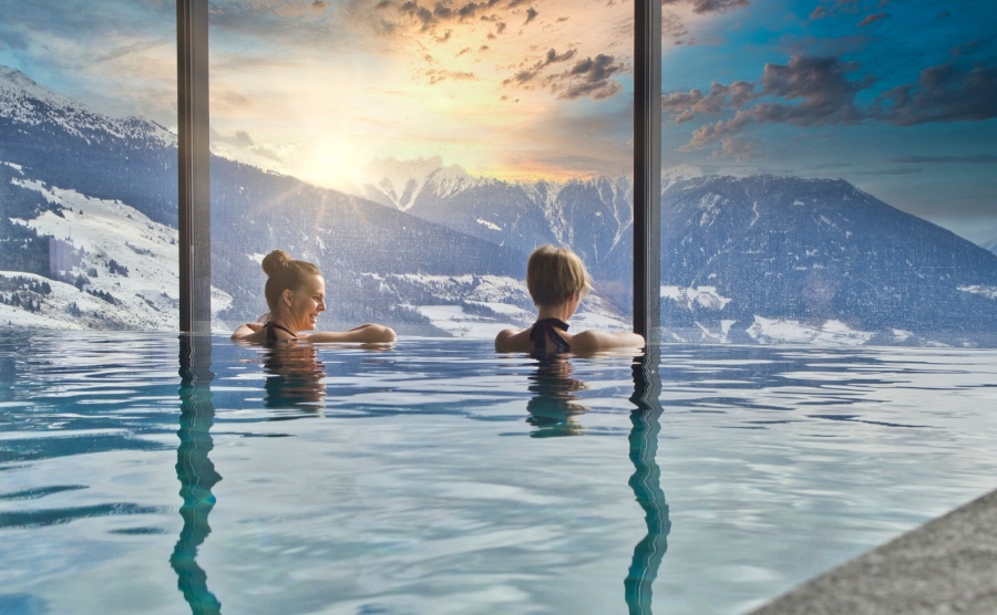 Women enjoying the view of the mountains from an indoor pool