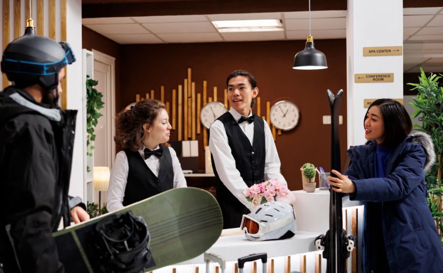 A happy couple talking to the concierge at a ski resort